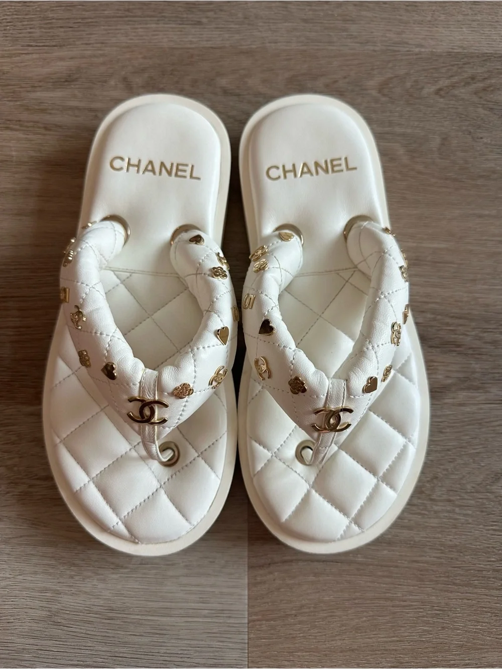 CHANEL 23S White Quilted Logo Flip Flops with Gold Charms